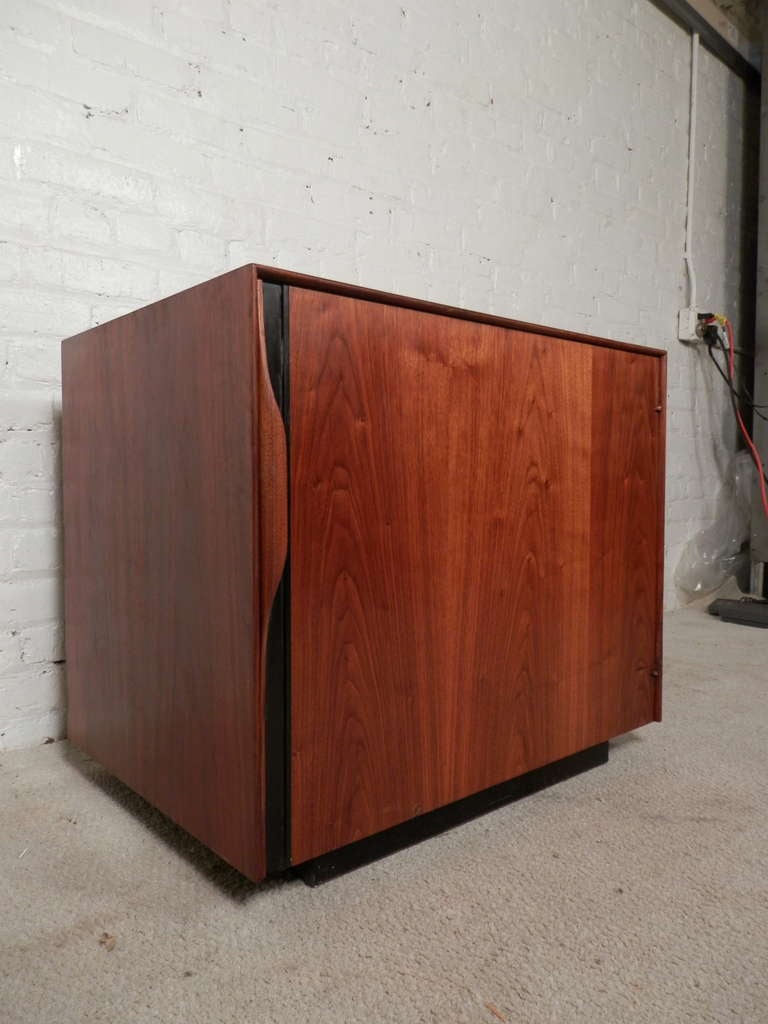 Super vintage single door cabinet with inside magazine rack, shelf, and pull out formica tray table. Designed by John Kapel and manufactured by Glenn of California. Cool modern design with multiple uses. Brilliant walnut grain, black handle and base