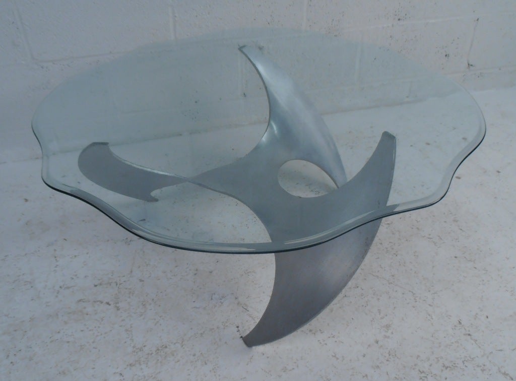 La base unique en aluminium supporte un plateau en verre à bord biseauté. Baptisée table Propeller en raison de son piètement métallique tourbillonnant, il s'agit d'une table au design emblématique.

(Veuillez confirmer l'emplacement de l'article