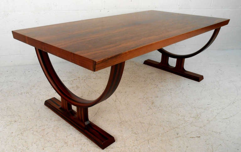 This expertly crafted Danish coffee table features rich Rosewood finish with a stunning sculptural base. This striking Scandinavian Modern design makes the table a memorable addition to any interior.  Please confirm item location (NY or NJ).