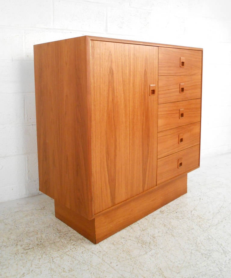 This vintage armoire features beautiful teak construction and offers plenty of storage for any room. Unique drawer pulls and beautiful wood grain make this a wonderful example of mid-century Scandinavian design. Please confirm item location (NY or