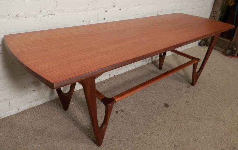 Exquisite Danish modern cocktail table with stunning sculpted base. Attractive teak grain, long top with curved edges, well constructed and newly refinished.

(Please confirm item location - NY or NJ - with dealer).