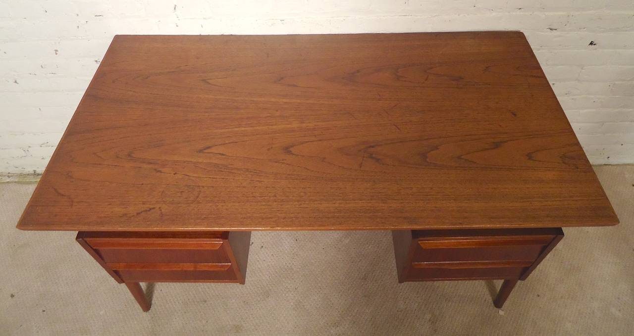 Midcentury writing desk filled with angles! Floating top design, slanted drawers with sculpted handles, tapered legs, finished with an angled back. Four drawers, two back cubbies and drop down cabinet. A highly designed, well made piece.
Key