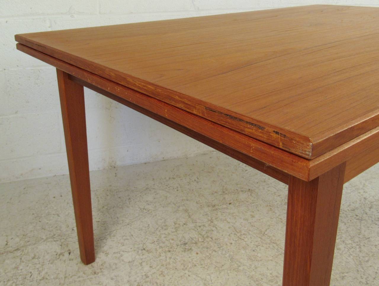 This stylish Danish modern dining table features a vintage teak finish and draw leaf design, expanding to almost 90 inches wide. Please confirm item location (NY or NJ).


Measure: Max length 89.5
