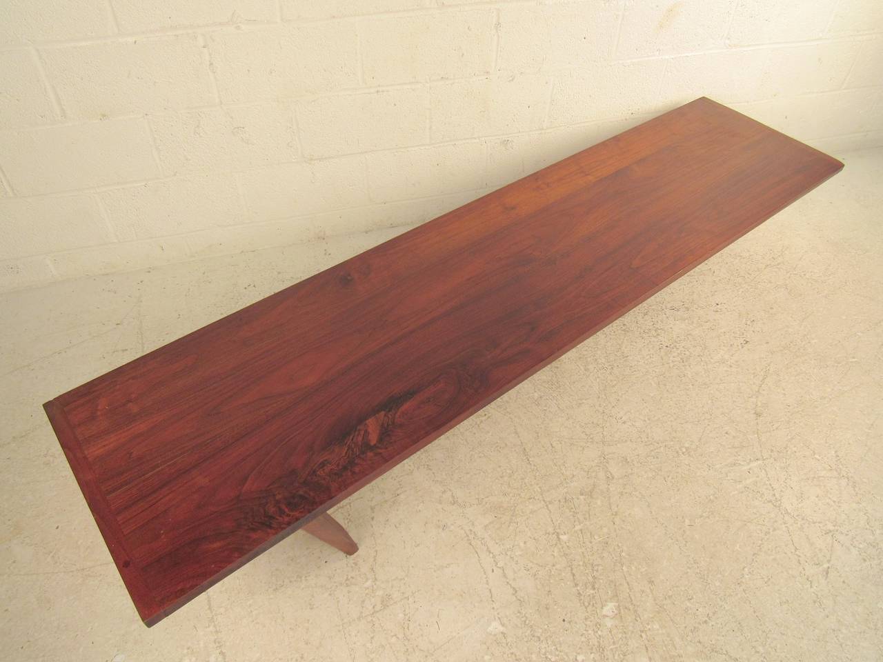 Beautiful Midcentury coffee table designed and inscribed by artist Robert Jay Lawrence in 1959. Unusual three leg construction with rich walnut top. For use as a coffee table or bench. A special, one of a kind piece.

(Please confirm item
