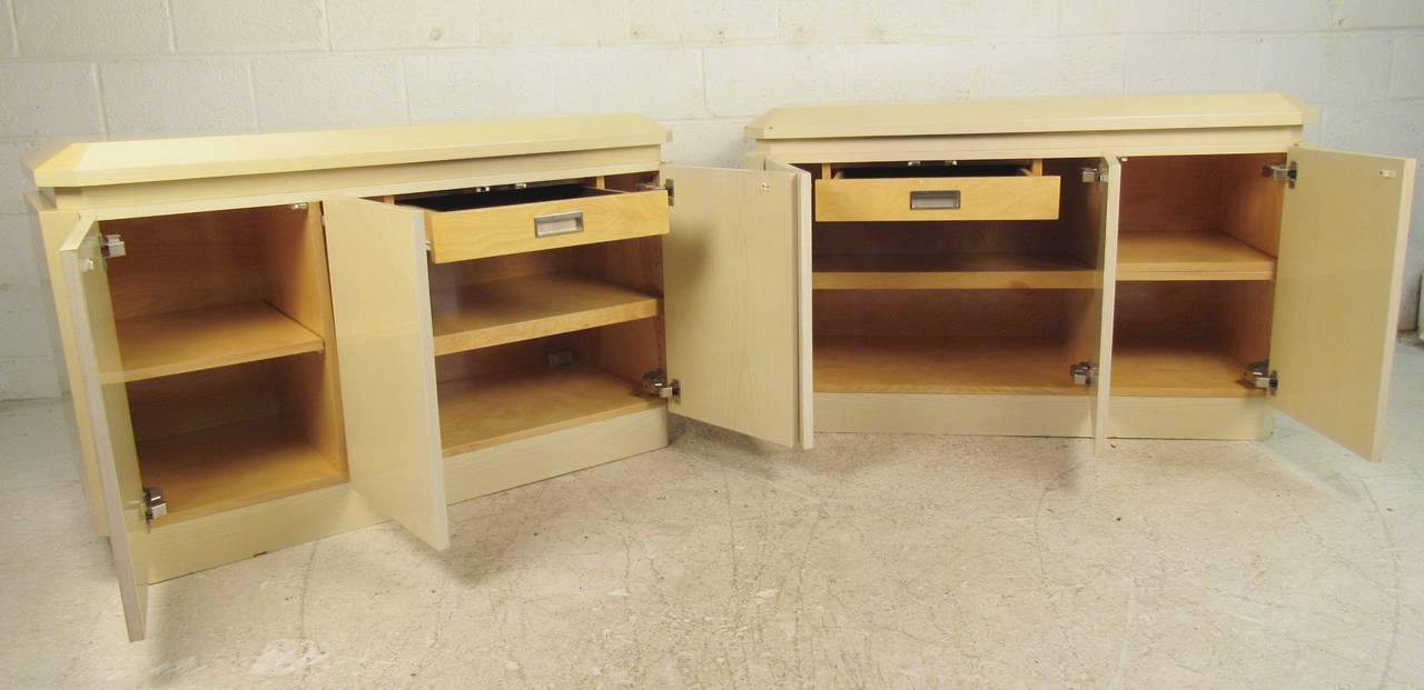 Pair of Mid-Century Modern matching cabinets in white lacquer finish. Three-door, double cabinet, adjustable shelves, felted drawers. Stylish Karl Springer style storage credenzas ideal for dining room or office storage. 

(Please confirm item