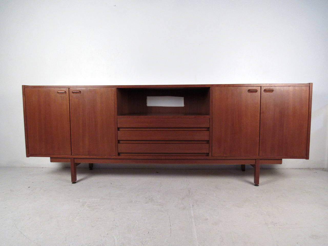 This Danish teak server features two cabinets with carved pulls, felt lined drawers, adjustable interior shelves and a unique stretcher base which offers a modern flare and ample storage to any home or office space.

Please confirm item location