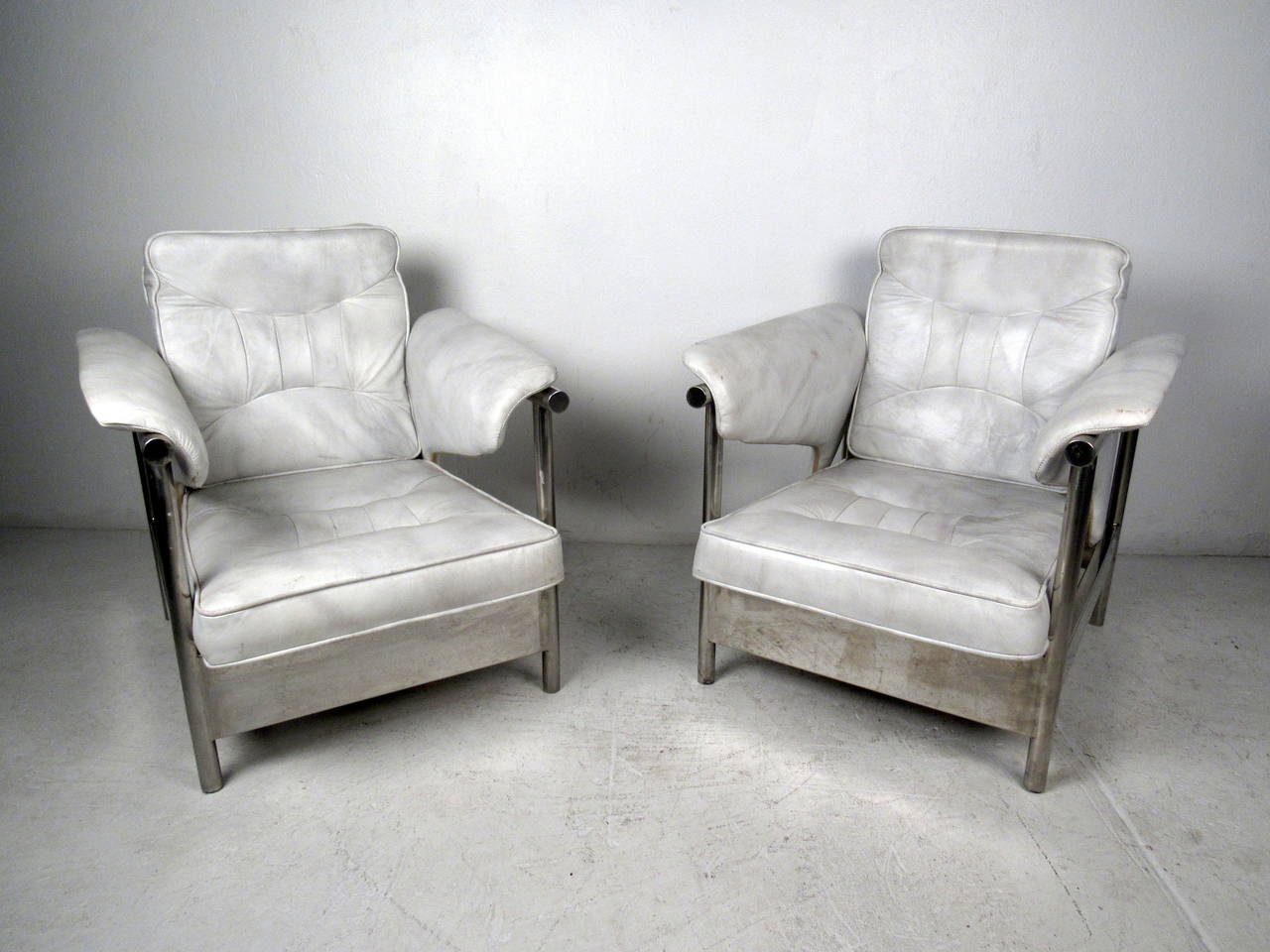 This pair of Italian lounge chairs feature a heavy chrome frame and vintage white leather upholstery which offer a bold modern flare to any home or office space.

Please confirm item location (NY or NJ) with dealer.