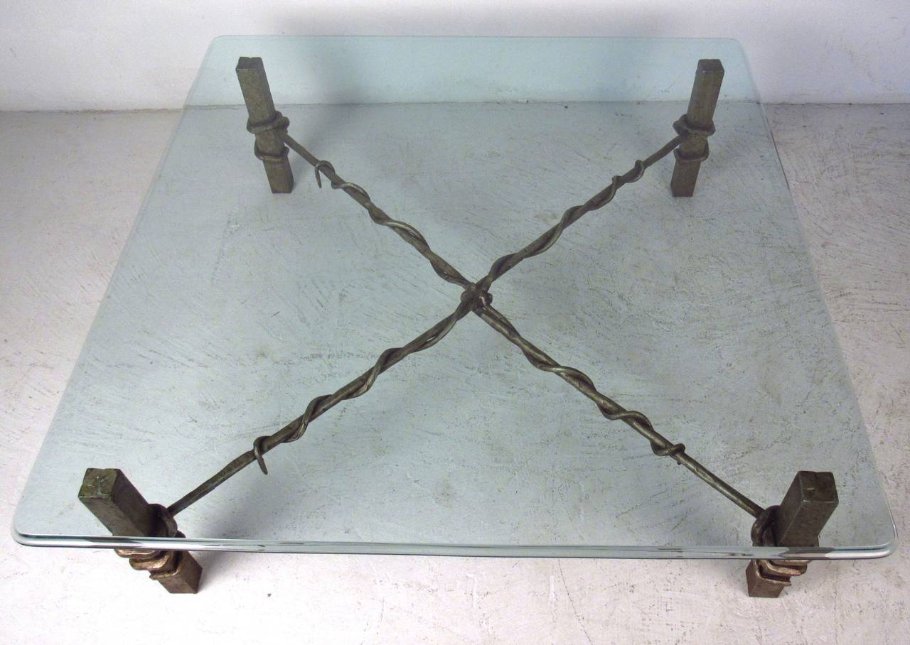 Primitive/industrial style coffee table with heavy hammered iron base and beveled glass top. Please confirm item location (NY or NJ) with dealer.