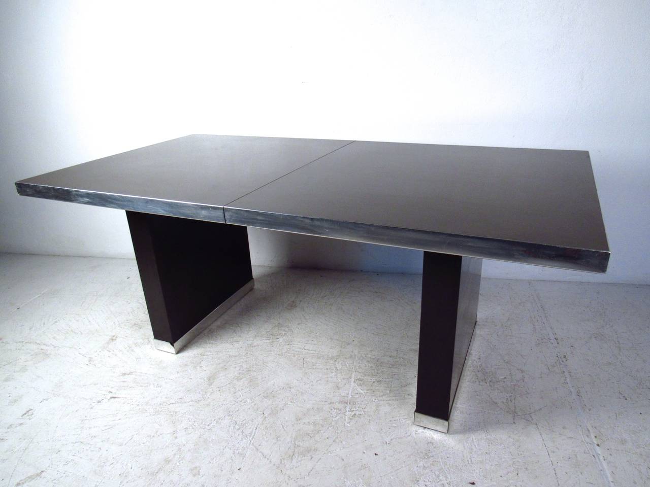 This beautiful dining table was designed by Pierre Cardin and features stylish chrome trim and two leaves for added length (20