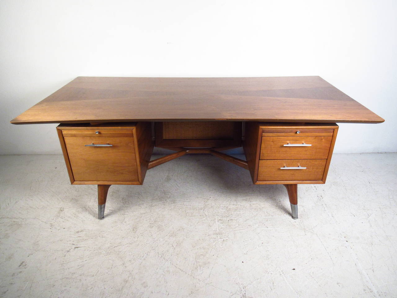 This beautiful vintage executive desk is a large and stylish solution for any workspace. Plenty of drawer storage, added pullout work surfaces, and wonderful style components. Tapered legs, cane back, and unique drawer pulls compliment the unique