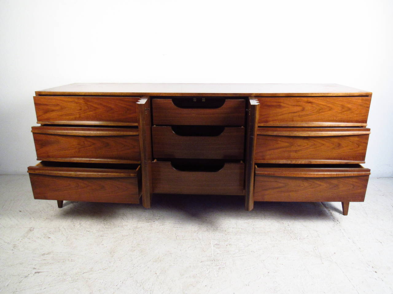 The beautiful lines on this vintage dresser perfectly compliment the wonderful walnut finish. Tapered legs and plenty of storage space make this the perfect piece for any interior. Please confirm item location (NY or NJ).
