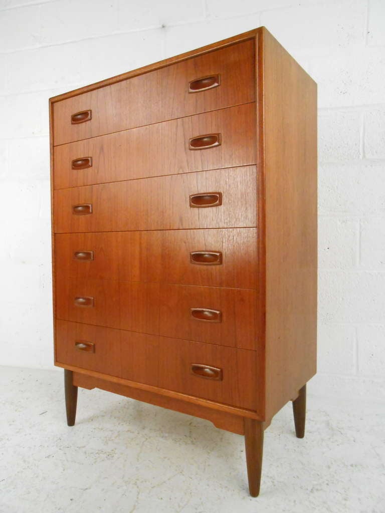 Danish six-drawer chest in teak makes a stylish Scandinavian Modern addition to any interior. Mid-Century Modern construction and design includes dovetailed drawers, sculpted handles, and tapered legs. Please confirm item location (NY or NJ) with