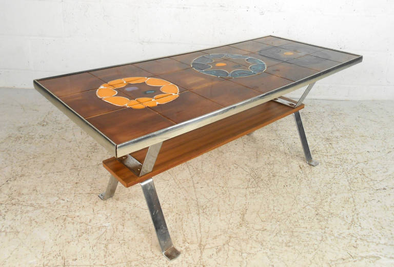 This decorative vintage coffee table features sturdy chrome legs supporting an artistic tile tabletop. Features a secondary shelf for storage and makes a colorful and unique addition to any home or business. Please confirm item location (NY or NJ).