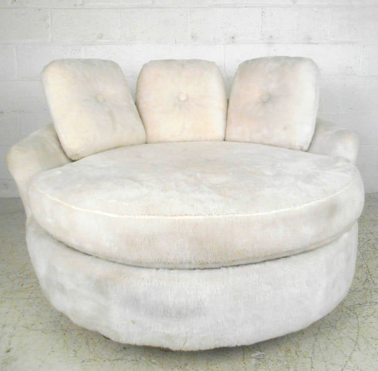 This ample-sized disc shaped lounge chair features tufted fabric, covering a large low back seat. Accompanied with matching cushions this unique piece makes an interesting and comfortable addition to any home or business. Please confirm item