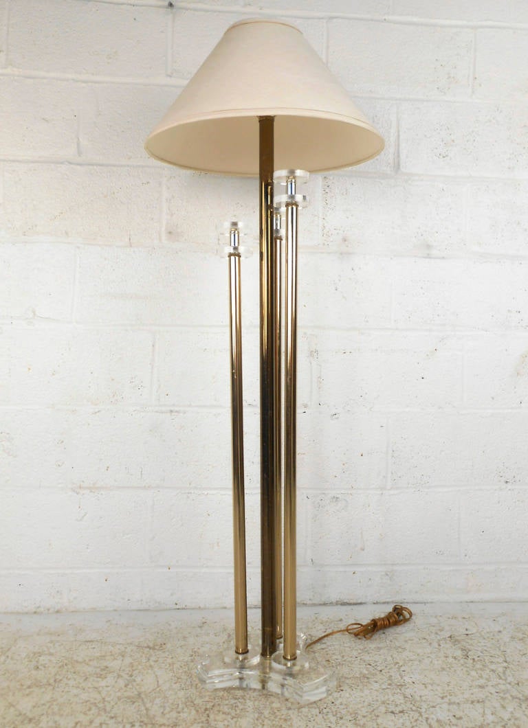 This beautiful floor lamp combines brass and lucite to create a stylish mid-century lighting solution perfect for any room. A truly unique and stunning piece, this lamp is functioning and includes matching vintage shade. Please confirm item location