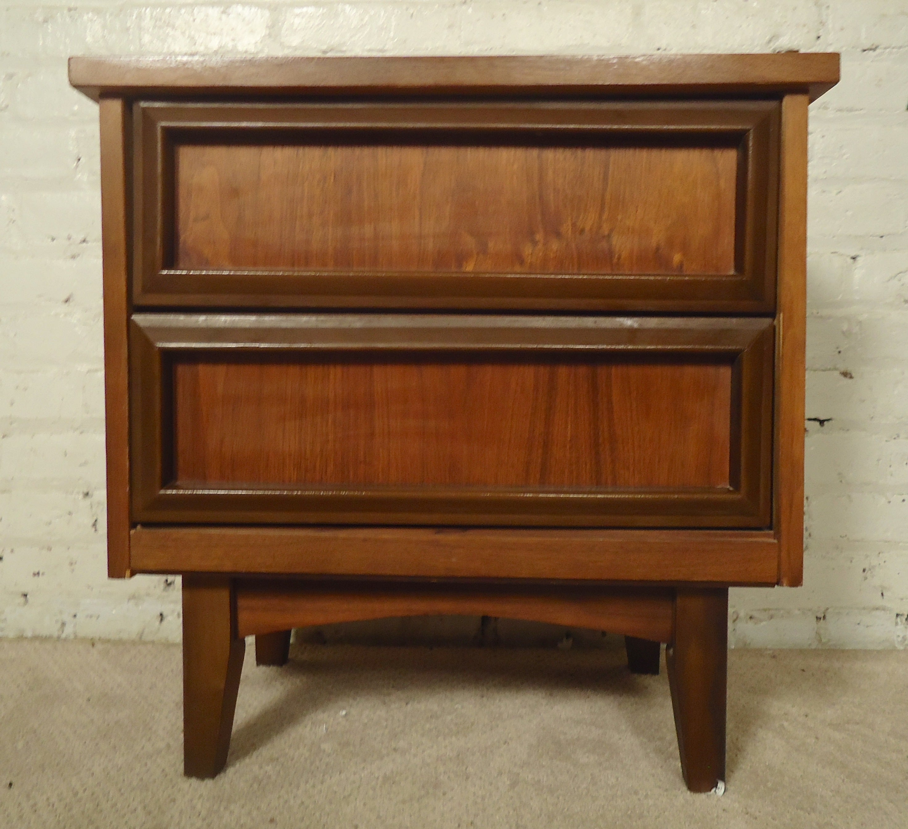 Simple modern lines with everyday function. Two drawers with darker trim handles around walnut grain. Good for bedside or living room.

(Please confirm item location - NY or NJ - with dealer)