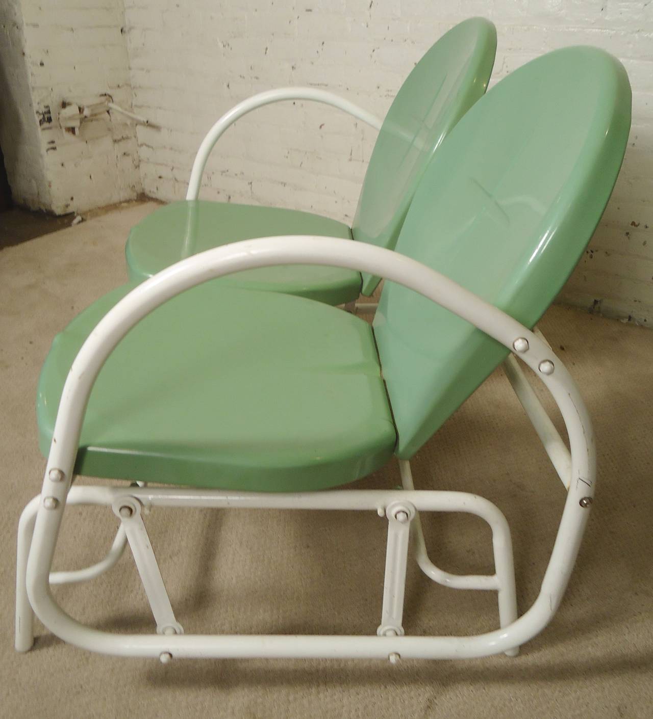 Metal gliding bench with vintage modern flair. Dramatic tubular arms, dual shell seats. Sturdy frame with relaxing gliding feature.

(Please confirm item location - NY or NJ - with dealer)