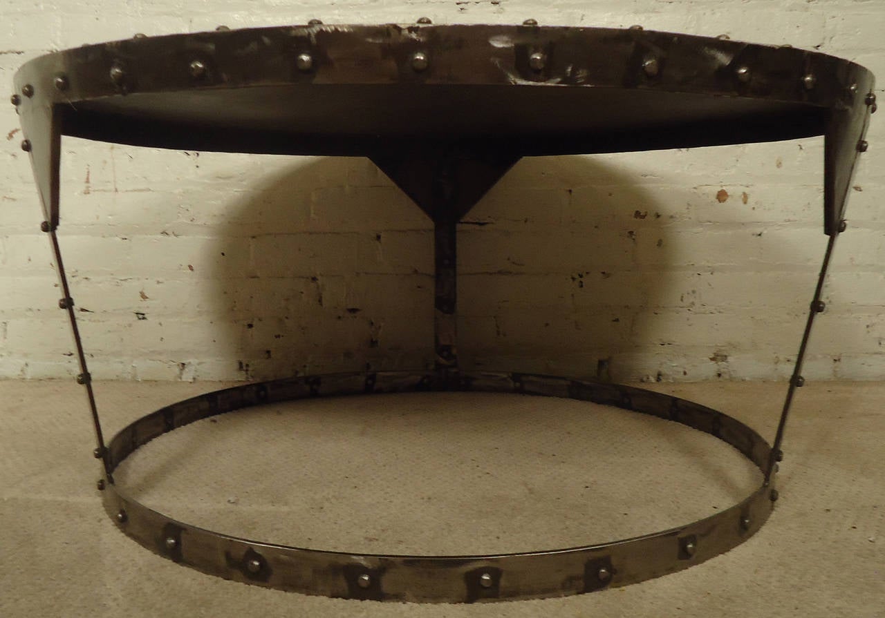 Distressed circular industrial-style metal coffee table, sturdy tapered base with riveted accents.

Please confirm location NY or NJ with dealer