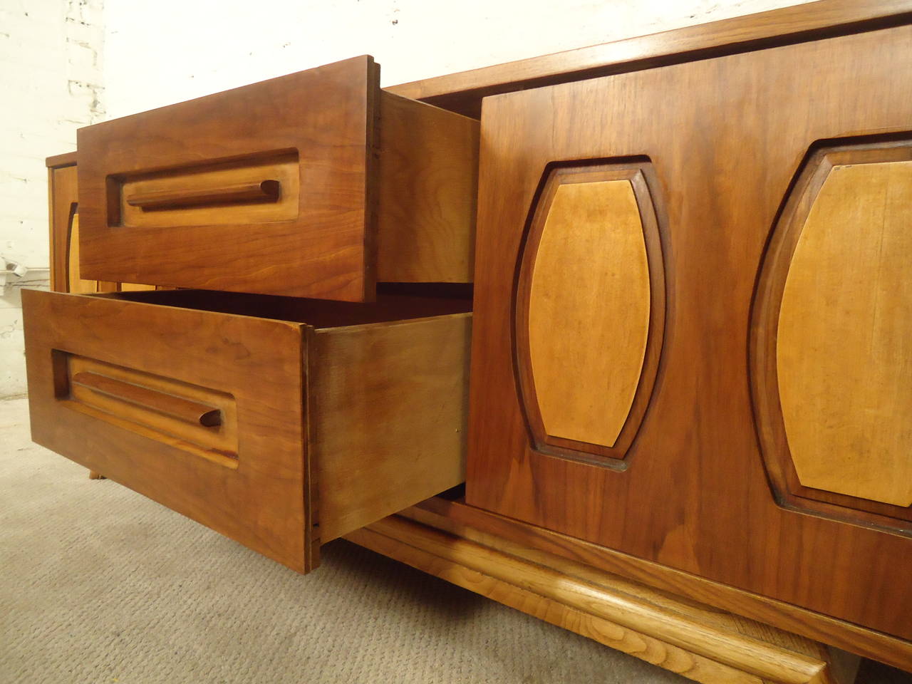Vintage credenza features beautiful walnut grain with oak accenting. Two large center drawers with sculpted wood handles, two sliding doors reveal two extra drawers and cabinet space. Shorter than normal credenzas, which makes for a great TV