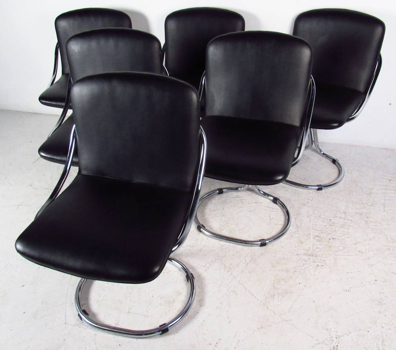 Set of six modern cantilever style dining chairs in black vinyl. Please confirm item location (NY or NJ) with dealer.