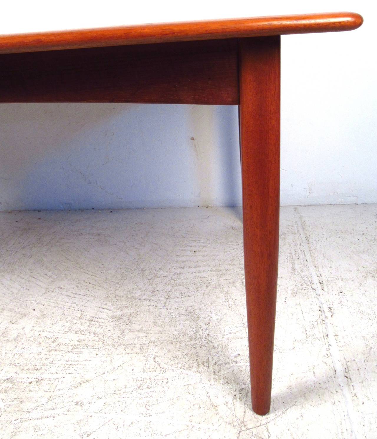 Mid century design teak dining table with two butterfly leaves that store under the table top. Each leaf is 20.75