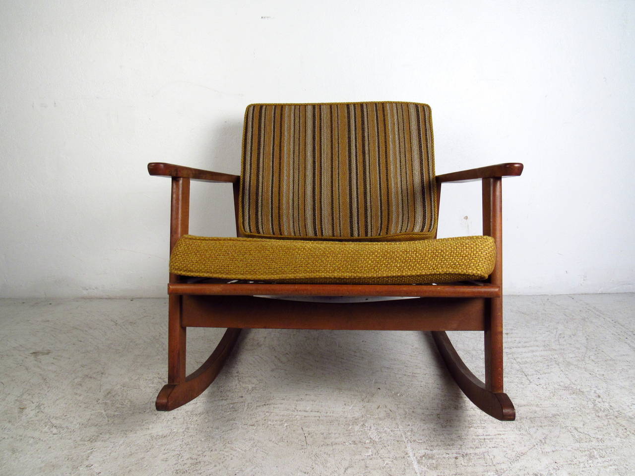 This mid century rocking chair features a solid walnut frame and comfortable vintage upholstery which offers a modern flare to any home or office space.

Please confirm item location (NY or NJ) with dealer.