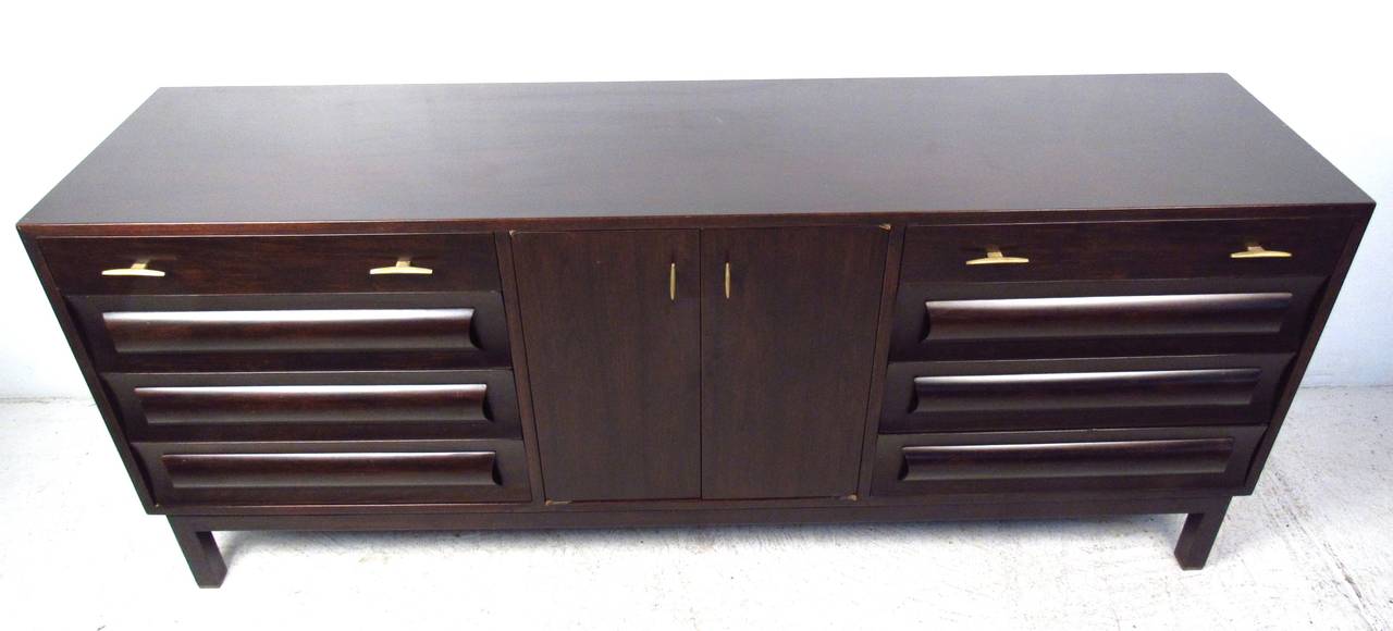 Impressive Edward Wormley for Dunbar bedroom dresser offers spacious storage in a rich wood finish. Beautifully detailed wood finish accented by brass pulls makes a striking addition to any interior. Please confirm item location (NY or NJ) with