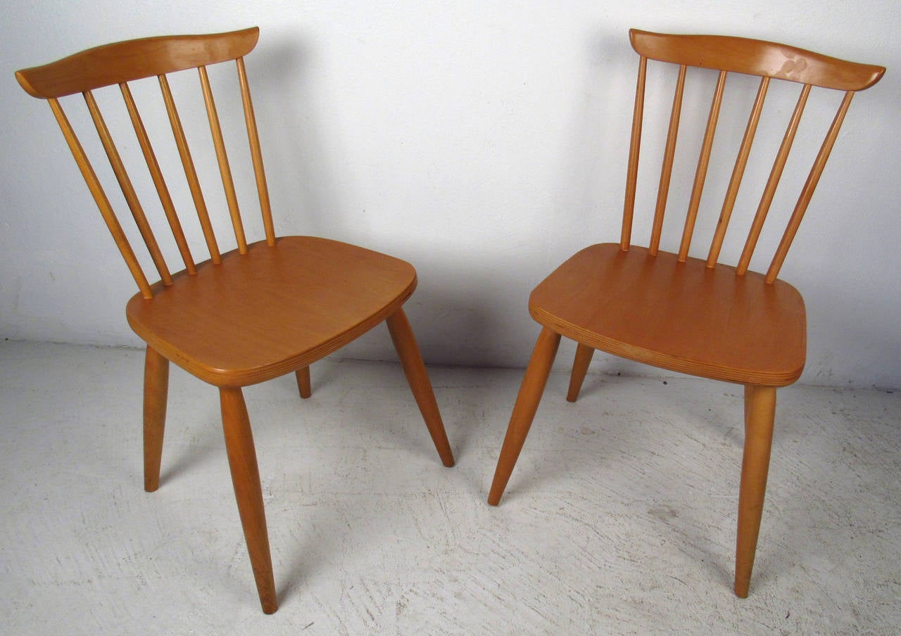 Two maple beautifully sculpted vintage-modern spindle back dining chairs. Designed in the manner of Paul McCobb. 

Please confirm item location NY or NJ with dealer.