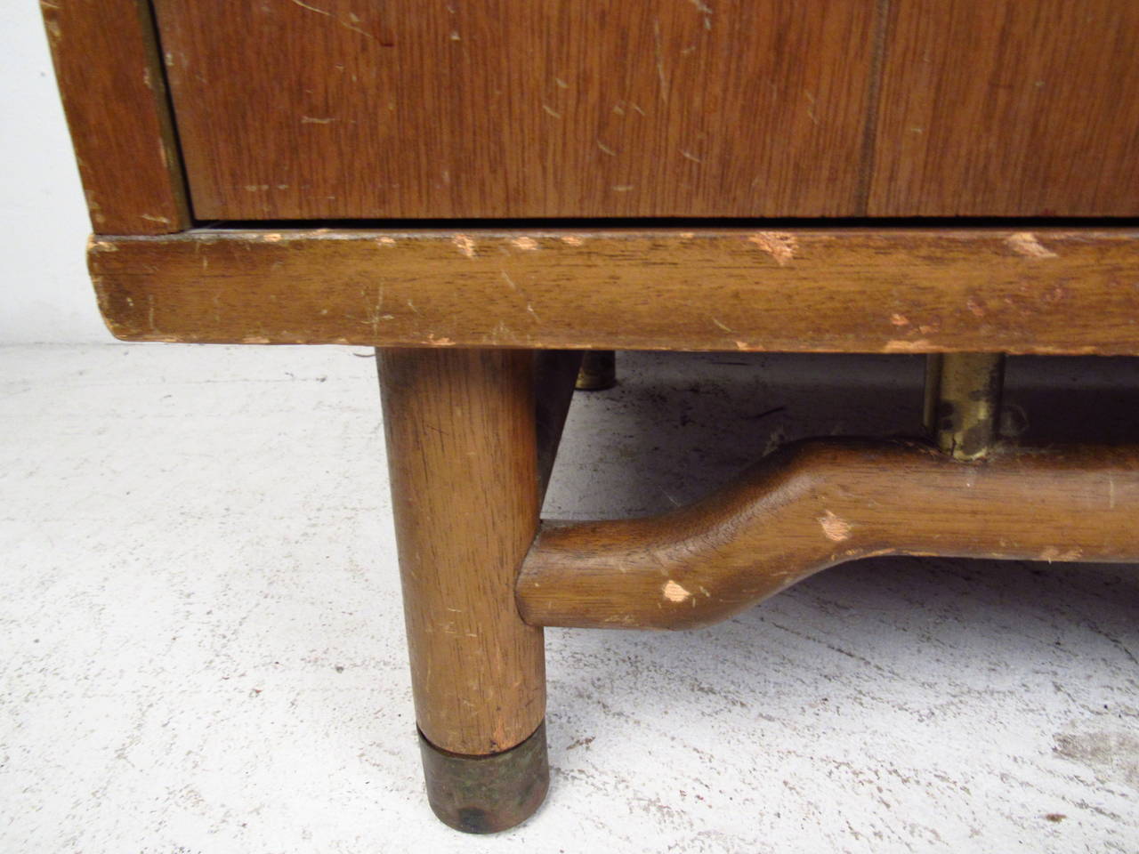 This pair of midcentury end tables features a solid wood construction, ornate brass hardware, and a unique stretcher base which offer an elegant flare to any home or office.

Please confirm item location (NY or NJ) with dealer.