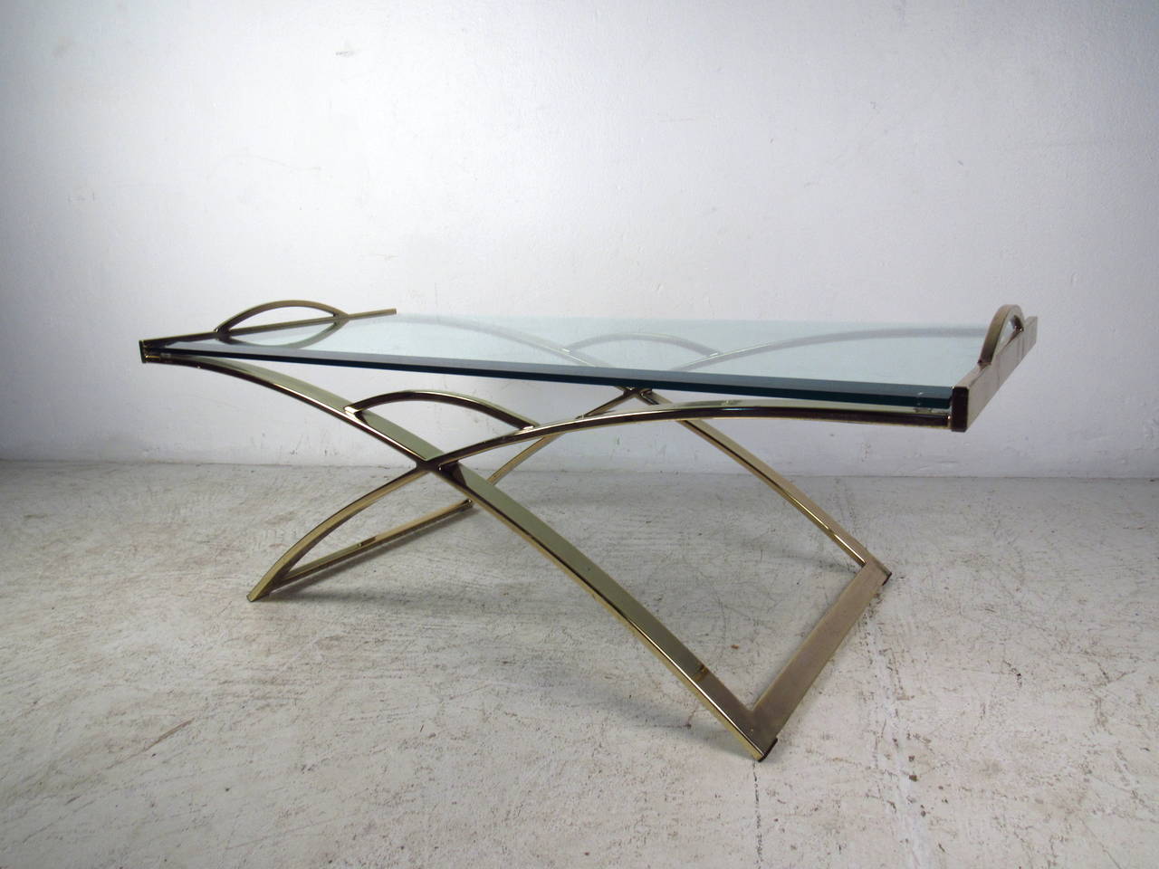 This midcentury coffee table features a unique design with a beautiful brass plated finish and bevelled glass top which offer a sleek modern flare to any home or office space.

Please confirm item location (NY or NJ) with dealer.