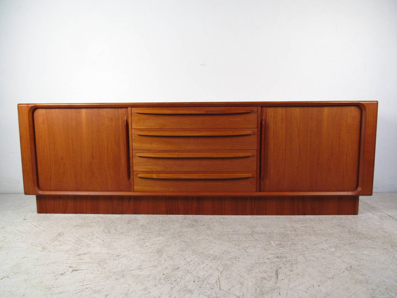 The beautiful teak finish on this unique sideboard makes the perfect mid-century addition to any interior. Plenty of storage options with seven drawers and added shelves make this a versatile piece for many situations. Manufactured by BPS of