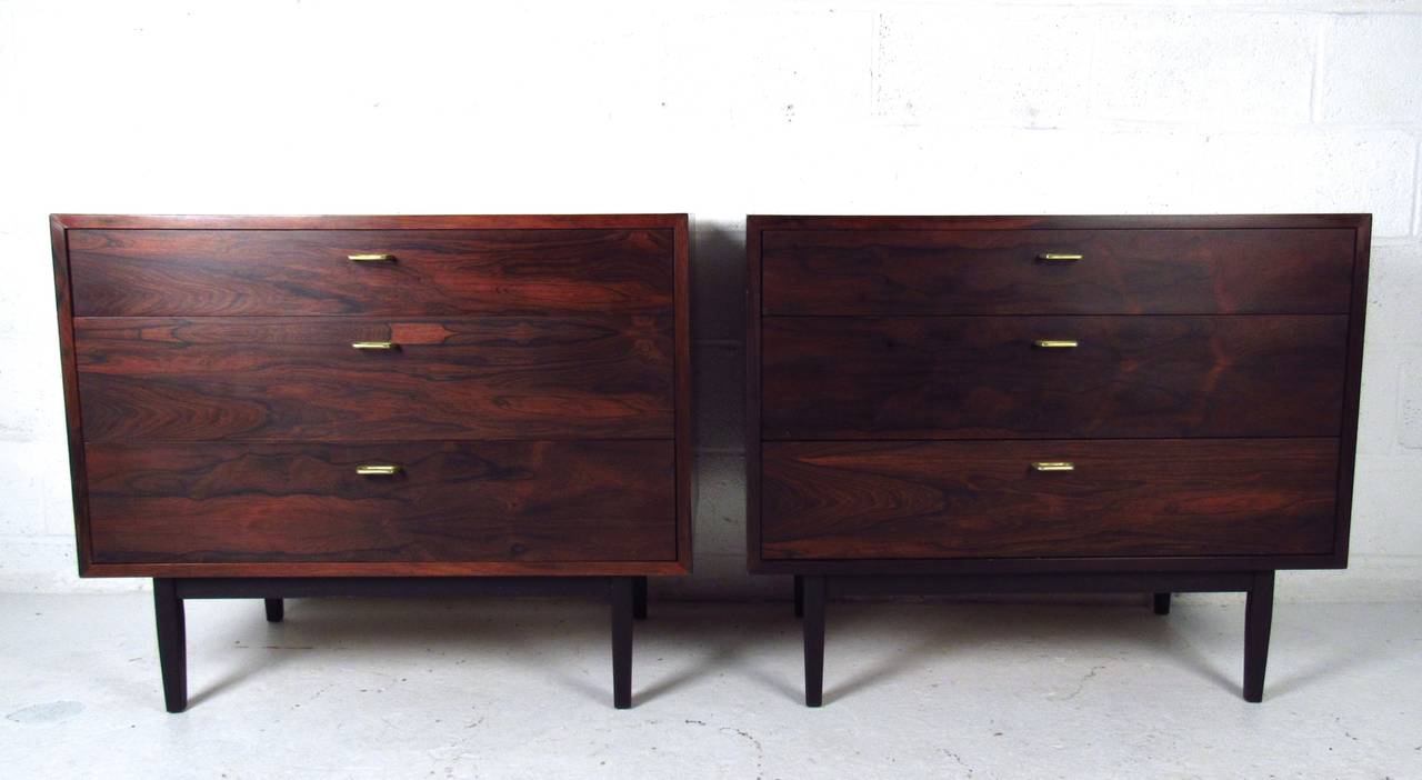 This beautiful pair of vintage dressers both offer three drawers for storage, unique pulls, and tapered legs. Quality construction and rich rosewood finish set these apart from other Mid-Century storage options. Please confirm item location (NY or