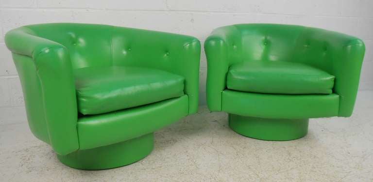 Striking midcentury pair of lime green vinyl chairs with swivel bases. Very comfortable club chairs for any setting. Please confirm item location (NY or NJ) with dealer.