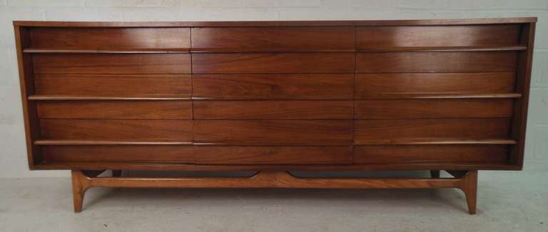 Long mid-century nine drawer dresser in walnut. Please confirm item location (NY or NJ) with dealer.