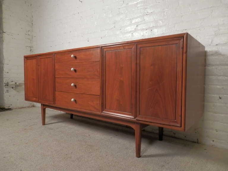 American walnut sideboard with two door side cabinets, each with interior lights, and four middle drawers with original porcelain ball & brass drawer pulls. Nice clean lines, great walnut grain.

(Please confirm item location - NY or NJ - with