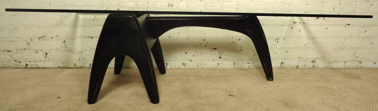 Vintage-modern coffee table, features beautifully sculpted black lacquer base with large rectangular glass top. Designed by Tonk Manufcaturing Co. Base can be arranged upside down or right side up.

Base measurements - 34w 18d 15h

Please confirm