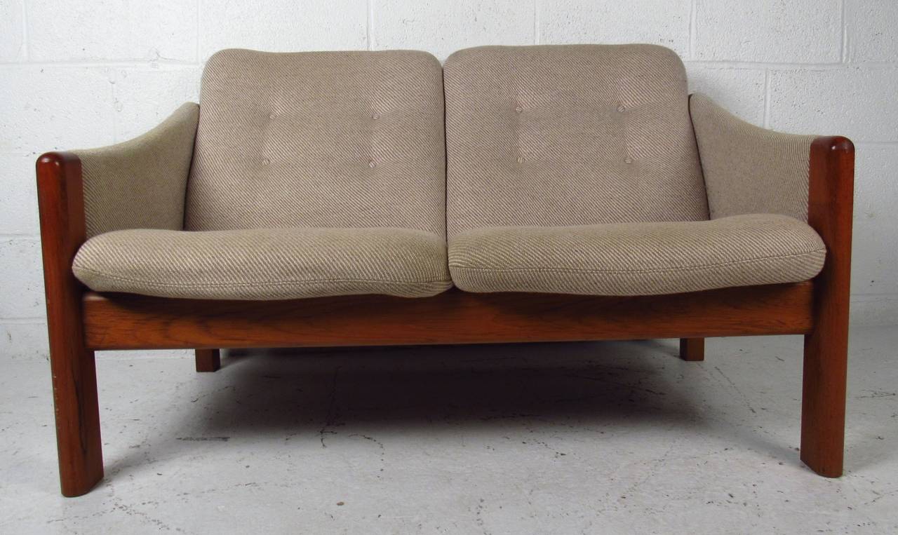 Two seater Danish modern upholstered settee with teak frame. Please confirm item location (NY or NJ) with dealer.