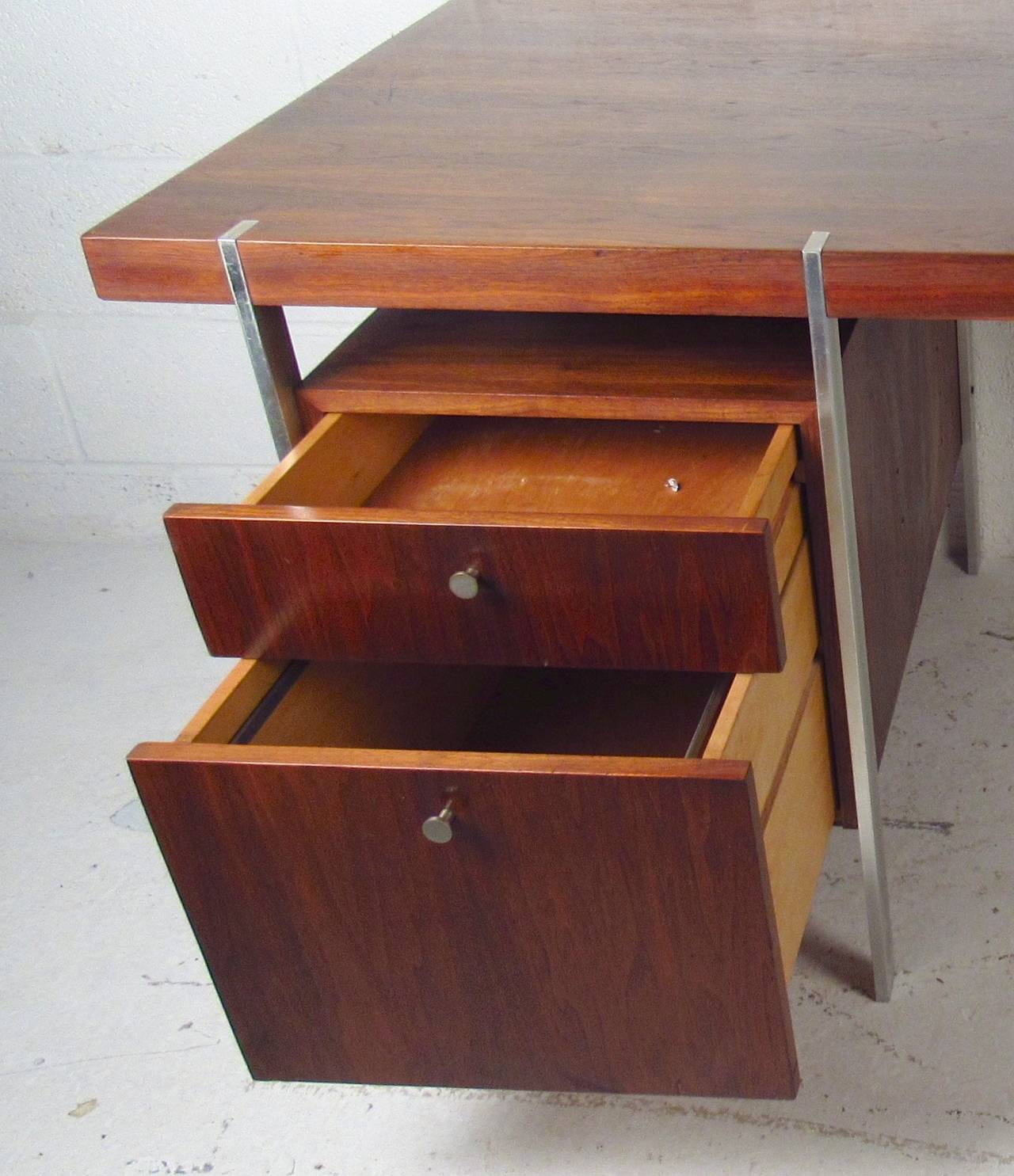 Seek and simple mid-century desk with floating style top and polished chrome legs. Two drawers with matching chrome pulls, large walnut top.

(Please confirm item location - NY or NJ - with dealer)