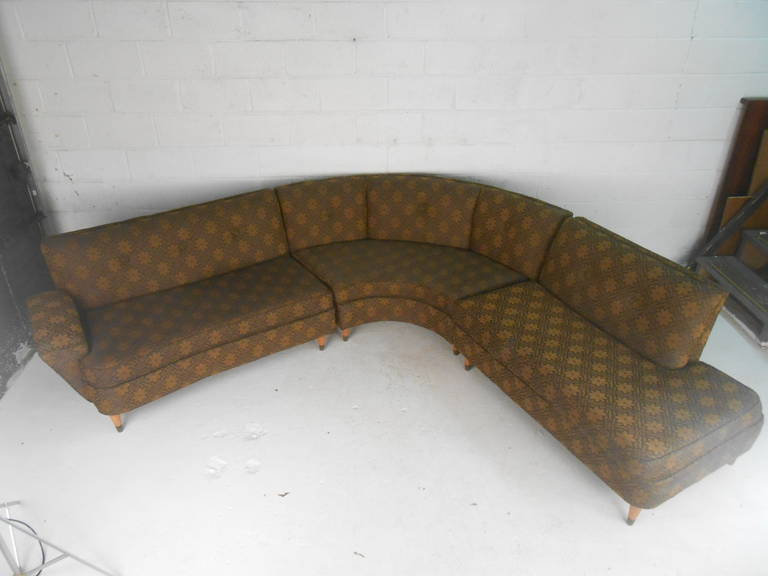 Mid-Century Modern three-piece sectional sofa with original floral design makes a comfortable and stylish addition to any interior. Unique vintage upholstery in excellent condition, complimented by tapered hardwood legs with brass sabots. 

(Please