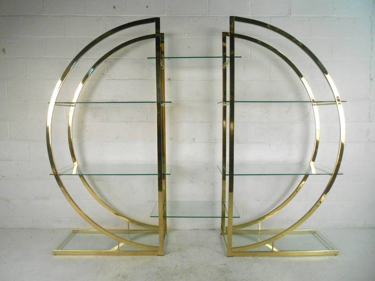 Large brass plated etagere in the style of Milo Baughman. Pair of semi-circle brass shelving units that come together with eight glass shelves total. Can be used as two separate units by not using the center shelves. Magnificent design!

(Please