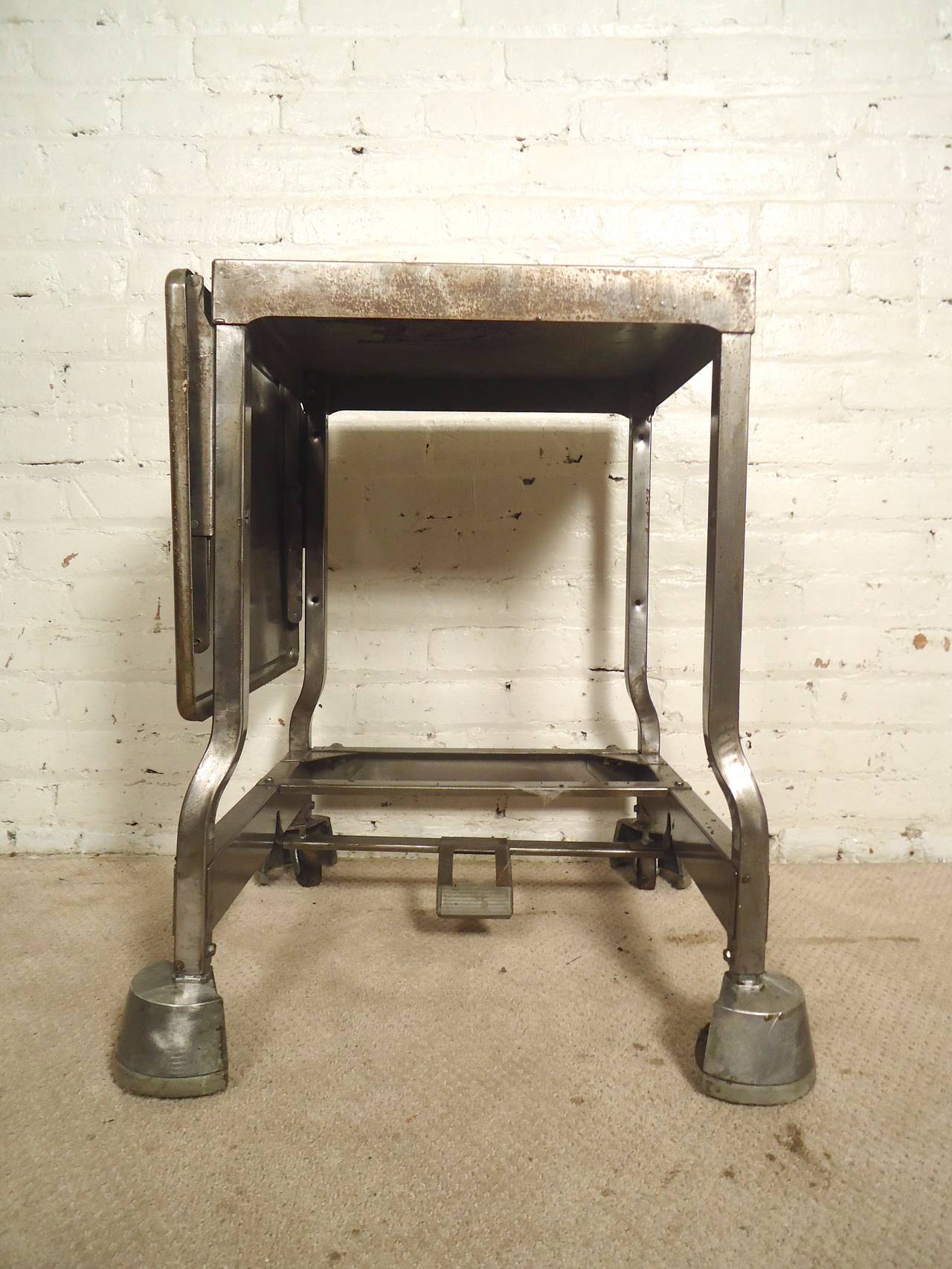 Dieser Tisch aus der Fabrik wurde aufgearbeitet und als schicker Beistelltisch im Industriestil mit ausziehbarer Platte wiederverwendet. Feststellbare Rollen, Stil aus blankem Metall, einzigartiger Wohn- oder Bürotisch.

(Bitte bestätigen Sie den