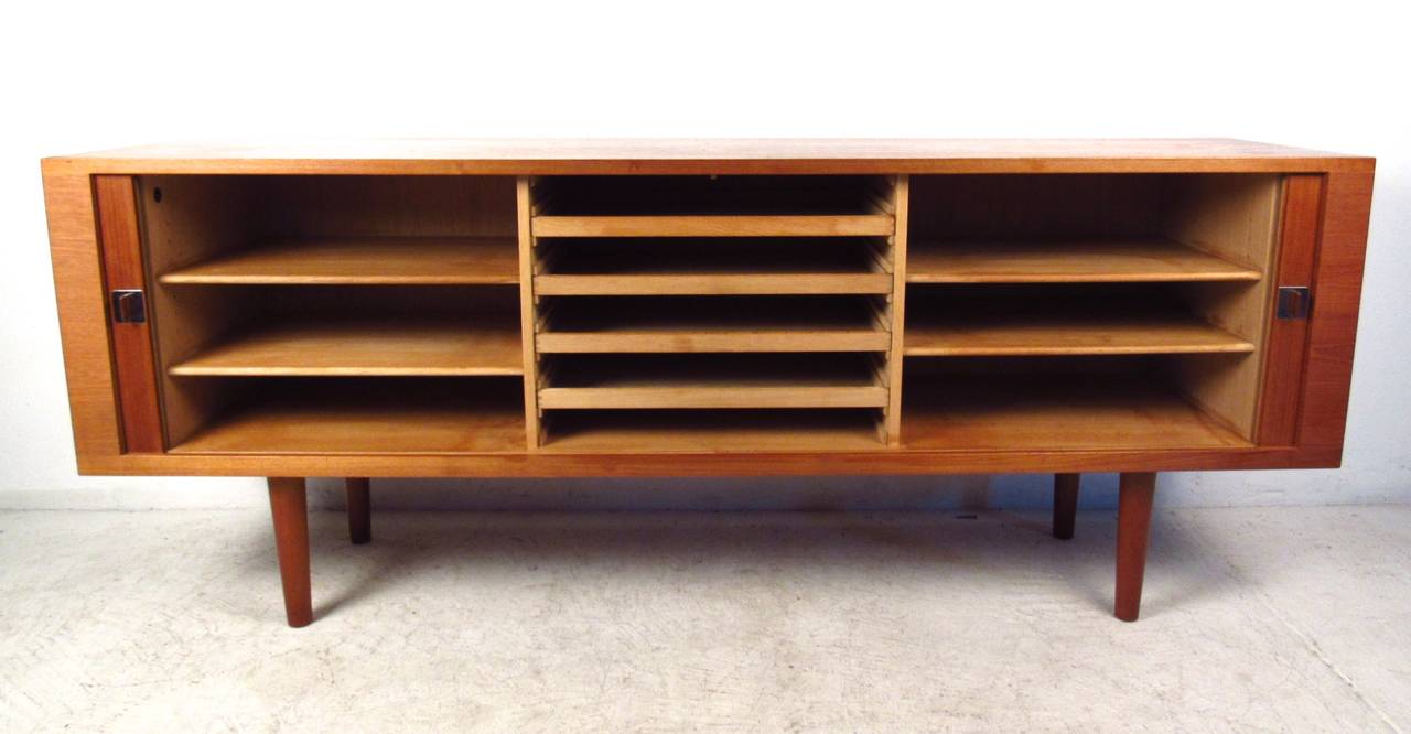 This beautifully crafted vintage Danish credenza features smooth operating tambour doors, unique chrome and teak pulls, plenty of shelves for organization and the original Danish Control mark. Manufactured by Ry Møbler in the mid-1960s this piece