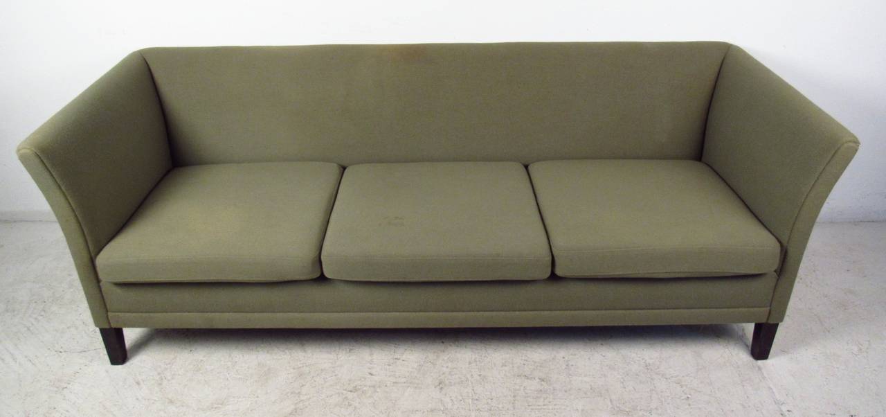 Three-seat sofa in the style of Kaj Gottlob, Denmark. A Sleek design with winged arm rests and three overstuffed removable cushions. This comfortable mid-century modern green sofa makes the perfect addition to any seating arrangement. Please confirm