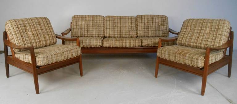 Well designed and constructed sofa and matching side chairs in solid teak. Graceful sloping arms with sturdy frames and ample cushions create a very comfortable seat. The sofa also converts to a daybed as well. Please confirm item location (NY or