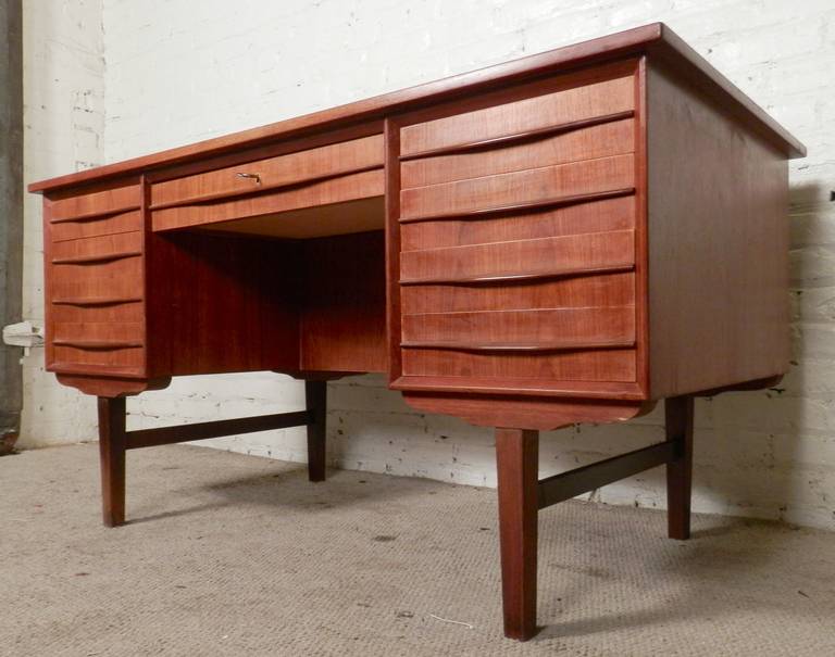 Vintage modern desk with nine total drawers and great teak grain. Large writing surface, sculpted handles, also features a finished back with three cabinets.

Kneehole: 23w 16d 24h

(Please confirm item location - NY or NJ - with dealer)