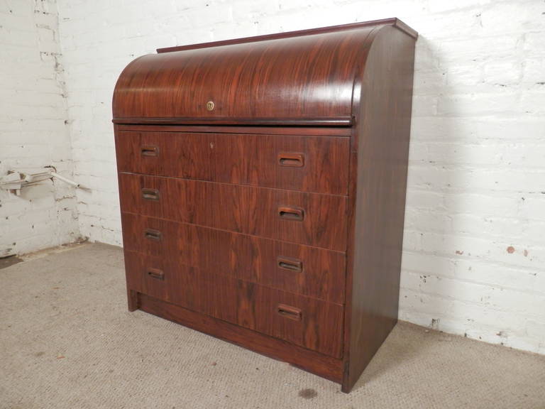 Mid-Century Modern Danish rosewood roll top dresser with sculpted handles. Four drawers, top opens with lock, includes desktop three small shelves and three small drawers.

(Please confirm item location - NY or NJ - with dealer)