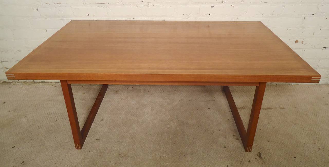 Midcentury table with sled legs, teak grain and unique metal inlay corners. Straight forward modern lines with a touch of distinct flair.

(Please confirm item location, NY or NJ, with dealer).