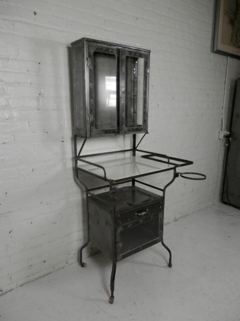 Industrial metal dental cabinet on casters. Awesome statement piece with milk glass shelf. Great for storage in bathrooms and kitchens with top and bottom cabinet, and drawer.