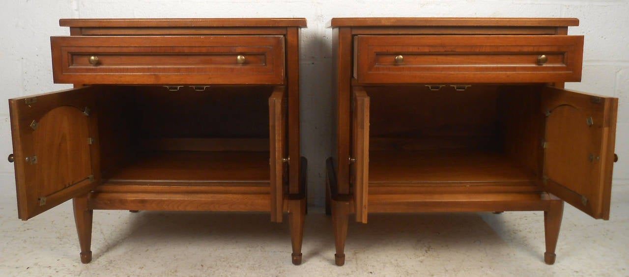 Two vintage-modern end tables, featuring one drawer and one cabinet each, sculpted brass pulls, and cane front. By 