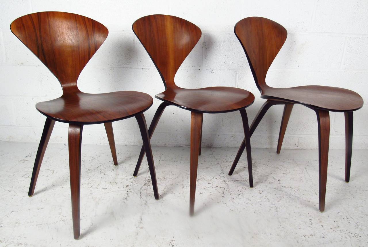 Set of three bent plywood chairs by Norman Cherner for Plycraft available, this posting is for ONE chair from the set. An iconic design with a one of a kind shaped frame. A lovely wood grain, splayed legs, and elegant wood grain throughout shows